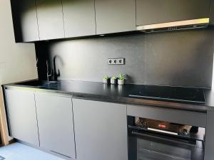 a kitchen with white cabinets and a stove top oven at gite du château in Montfaucon