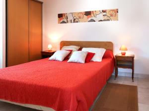 a bedroom with a red bed with white pillows at Holiday Home Ty Kerzo by Interhome in Plouhinec +21 photos