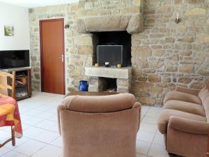 a living room with two chairs and a stone fireplace at Holiday Home Ty Kerzo by Interhome in Plouhinec