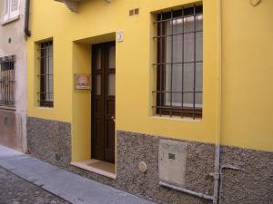 a yellow building with a brown door and windows at La Cervetta in Mantova