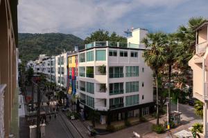 un edificio bianco con palme in città di Grand Orlov Apart Hotel a Patong Beach