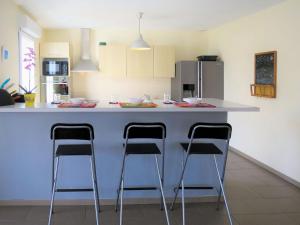 una cocina con encimera con 3 taburetes en Villa Nael by Interhome, en Vendays-Montalivet