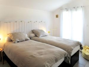 Un dormitorio con dos camas y una ventana. en Holiday Home Mon Poussin by Interhome, en Saint-Vivien-de-Médoc