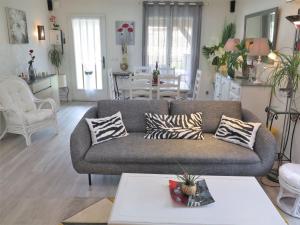 a living room with a couch and a table at Holiday Home Les Camélias by Interhome in Labenne