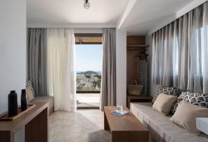 a living room with a couch and a large window at Poseidon Villas in Skiathos Town