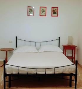 a bed in a bedroom with two tables and two pictures on the wall at Agriturismo Donna Clementina in Castellaneta Marina