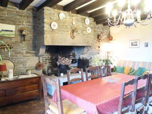 a dining room with a table and a fireplace at Holiday Home La Longère by Interhome in Vains +20 photos