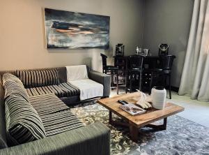 uma sala de estar com um sofá e uma mesa de centro em Tredenham Boutique Hotel em Bloemfontein