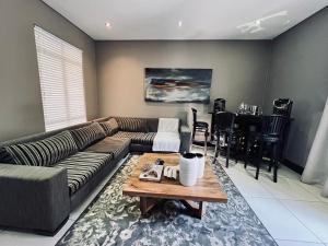 een woonkamer met een bank en een tafel bij Tredenham Boutique Hotel in Bloemfontein