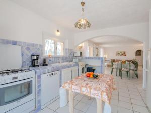 a blue and white kitchen with a table with a bowl of fruit at Holiday Home Mas des Chênes by Interhome in Grimaud