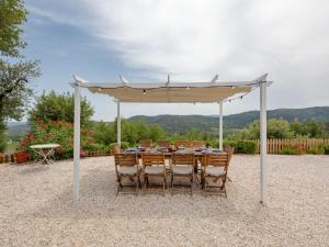 a table and chairs under a white umbrella at Holiday Home Mas des Chênes by Interhome in Grimaud