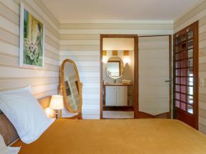 a bedroom with a bed and a mirror and a sink at Holiday Home La Haute Gilberdière-2 by Interhome in Sartilly