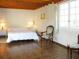 una camera da letto con un letto, due sedie e una finestra di Holiday Home Stergann by Interhome a Mesquer