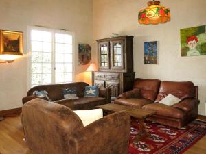 un soggiorno con mobili in pelle marrone e lampadario pendente di Holiday Home Stergann by Interhome a Mesquer Altre 27 foto