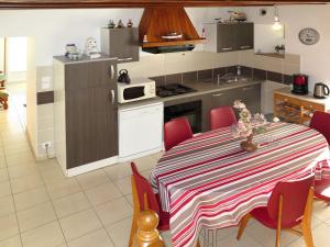 una cucina con tavolo e sedie rosse intorno di Holiday Home Chez Yvonne by Interhome a Pleubian