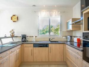 a kitchen with wooden cabinets and a window at Holiday Home Ker Laouen by Interhome in Kerlouan