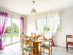 a dining room with a table and chairs and windows at Holiday Home Ker Laouen by Interhome in Kerlouan +15 photos