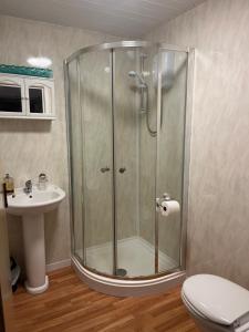 a shower in a bathroom with a toilet and a sink at Lindisfarne Holiday Apartments - Families & Couples Only in Blackpool +106 photos