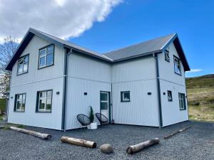 a large white house with a lot of windows at Lindarhóll Guesthouse in Stóri-Bakki