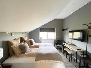 a bedroom with a bed and a desk in it at Lindarhóll Guesthouse in Stóri-Bakki