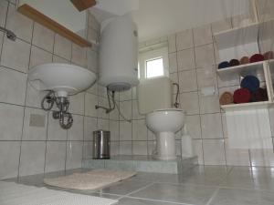 a bathroom with a toilet and two lights on the wall at Apartments Brkanac in Umag +28 photos