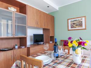 a dining room with a table with a vase of flowers at Apartment Le Margherite - SLR264 by Interhome in Costarainera