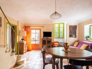 a living room with a table and a couch at Holiday Home La Maison du Figuier by Interhome in Saint-Montan