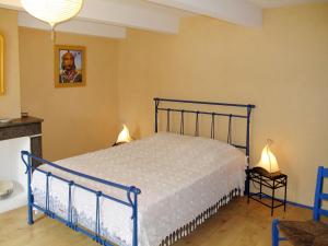 a bedroom with a blue bed in a room at Holiday Home La Maison du Figuier by Interhome in Saint-Montan
