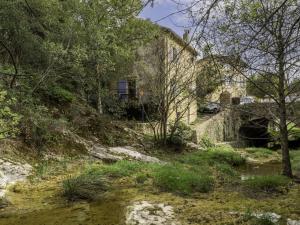 an old house on a hill next to a river at Holiday Home La Maison du Figuier by Interhome in Saint-Montan
