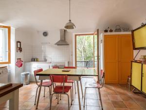 a kitchen with a dining room table and red chairs at Holiday Home La Maison du Figuier by Interhome in Saint-Montan +28 photos