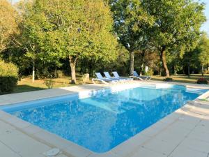 a swimming pool with chairs and trees in the background at Holiday Home Le Causse du Cluzel by Interhome in Pontcirq +19 photos