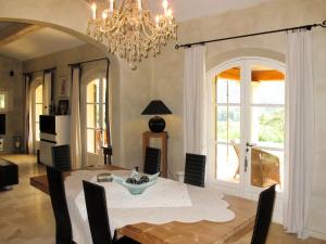 a dining room with a table and a chandelier at Holiday Home Le Mas de la Roche by Interhome in La Môle +13 photos