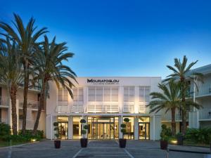 a building with palm trees in front of it at Mouratoglou Hotel & Resort in Biot