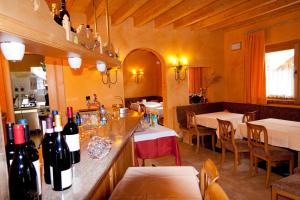 een restaurant met een bar met flessen wijn bij Bio Hotel Villa Cecilia in Livigno