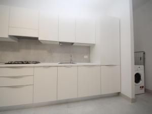 a white kitchen with a sink and a dishwasher at Apartment Marcello-7 by Interhome in Rosolina Mare +12 photos