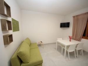 a living room with a green couch and a table at Apartment Marcello-7 by Interhome in Rosolina Mare