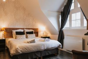 a bedroom with a bed with two towels on it at La Villa in Mesnil-Val-Plage