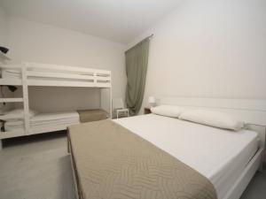 a bedroom with a white bed and a shelf at Apartment Marcello-7 by Interhome in Rosolina Mare