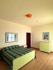 a bedroom with a bed and a dresser at Villa Nettuno Residence in Giardini Naxos