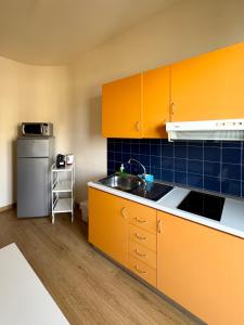 a kitchen with orange cabinets and a sink and a refrigerator at Villa Nettuno Residence in Giardini Naxos +69 photos