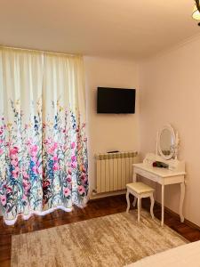 Una habitación con una ventana con una cortina de flores. en Dream Rooms, en Hunedoara 6 fotos más