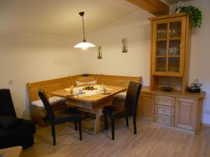 a dining room with a wooden table and chairs at Gästehaus Holzer in Viehhofen +3 photos