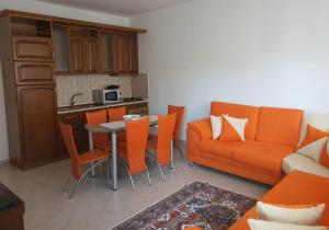 a living room with a couch and a table with orange chairs at Junaid Apartment in Golem
