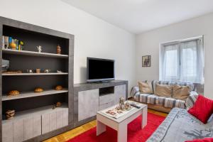 a living room with a couch and a tv at Casa Rosa Aosta in Aosta