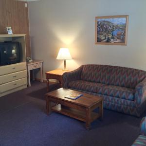 a living room with a couch and a coffee table at MacThrift Motor Inn in Virginia Beach
