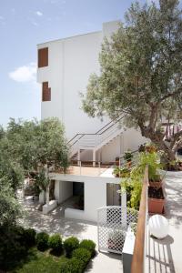 a white house with a staircase and trees at Akti Hotel Kavala in Paleo Tsifliki