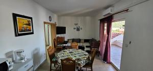 a living room with a table and chairs and a window at Apartman Darko in Rogoznica