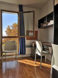 een kamer met een bureau, stoelen en een raam bij Studio lumineux 10 min à La Défense 2 in Rueil-Malmaison