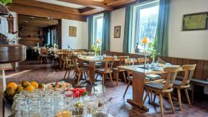 a dining room with tables and chairs and windows at Dorfgasthof "Zur Rose" in Obereisenheim
