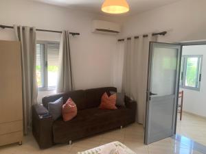 a living room with a brown couch with pillows at Villas Ermali in Ksamil
